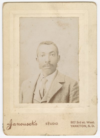 Fotografi av en mann iført en lys jakke, vest og slips, sent på 1800-tallet. av Louis Janousek