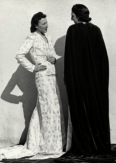 To modeller presenterer kreasjoner av det italienske couture-huset "Dragoni". En modell har på seg et antrekk i bleiemateriale som består av en jakke og et langt skjørt med tog. Den andre modellen, sett bakfra, bærer en lang fløyelsmantel. (s/hvi av Luis Bogino