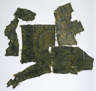 Fragmenter av en kaftan dekket med et silkestoff med et Senmurv-mønster. Moshchevaya Balka-begravelse M av Medieval Culture of the North Caucasian