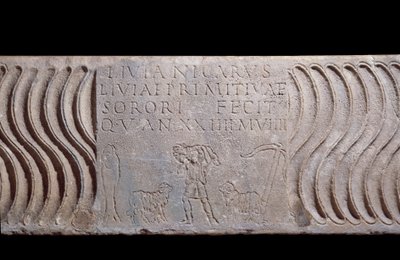 Paleochretian art: fragmentary sarcophagus tank: Good Shepherd and epitaph of Livia Primitiva. A shepherd with lambs, a fish (Christian symbol) and an anchor. Find in Rome under St. Peter