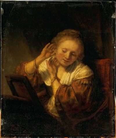 Ung kvinne som pryder seg med øredobber av Rembrandt van Rijn