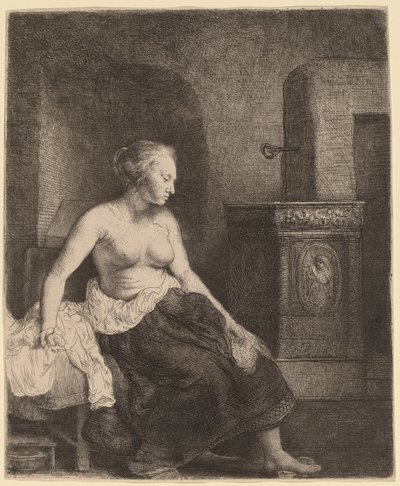 Kvinne som sitter halvkledd ved siden av en komfyr av Rembrandt van Rijn