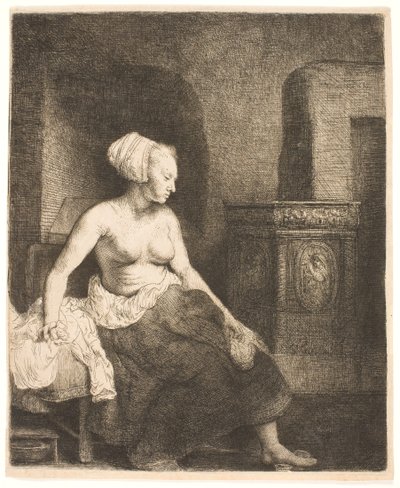 Kvinne som sitter halvkledd ved siden av en komfyr av Rembrandt van Rijn
