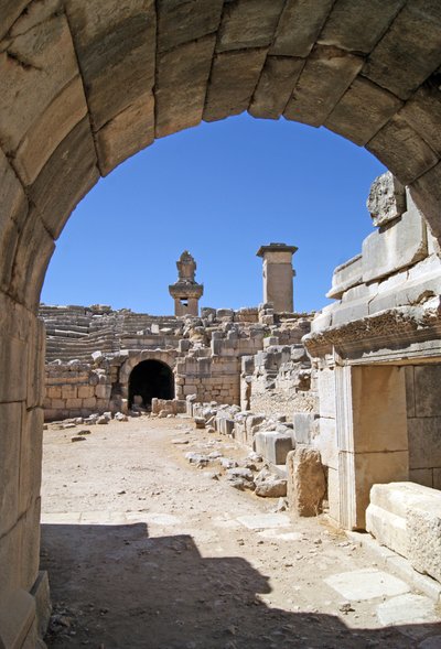 Utsikt gjennom den hvelvede inngangen til Xanthos-teatret inn i orkestergraven, og viser søyle og Harpy-grav, Xanthos, Tyrkia (bilde) av Roman