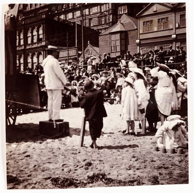 Publikum ser på en strandunderholder, ca 1905 av Unbekannt