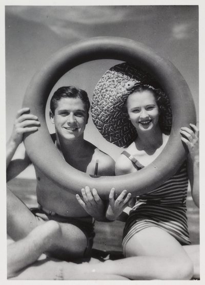 Mann og kvinne ser gjennom en gummiring på stranden, ca 1935 av Unbekannt