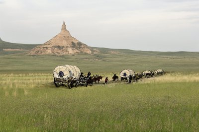 Historien om nybyggerne i Vest-Conquete: Amerikanske pionerer. Reiser til flere familier som krysser USAs sletter med flid. Flid som krysser Chimney Rock på Oregon Trail, Nebraska. Fargerik gravering kombinert med et fotografi. av Unbekannter Künstler