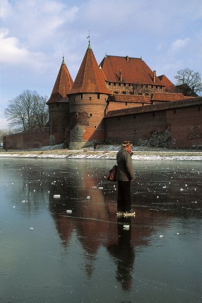 Sideprofil av en mann som står på en frossen elv foran et slott, Nogat River, Malbork Castle, Malbork, Pomorskie Province, Polen av Benjamin Baud