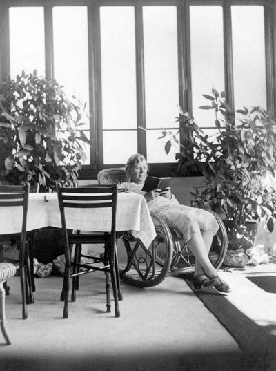 Kvinne som sitter i en gyngestol og leser en bok. Ca. 1915. Tyskland. Historisk bilde, kvinne som leser, ca. 1915. av Unbekannter Künstler