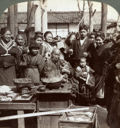 En gateartist med en ape som underholder publikum, Kobe, Japan, 1896. av Underwood and Underwood