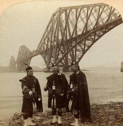 Menn i Highland kler seg foran Forth Bridge, Skottland. av Underwood and Underwood