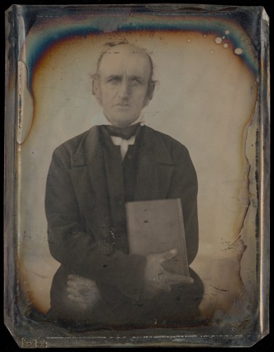 [Portrett av en mann med fårekotelett-værhår som klamrer seg til en bok] av Unknown artist