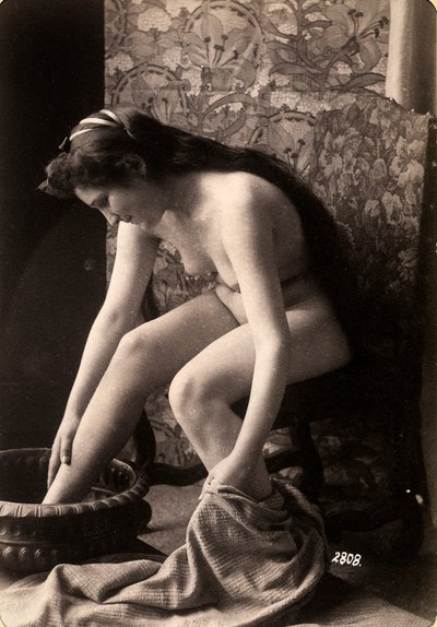 Portrett av en naken kvinne som vasker føttene sine av Unknown photographer