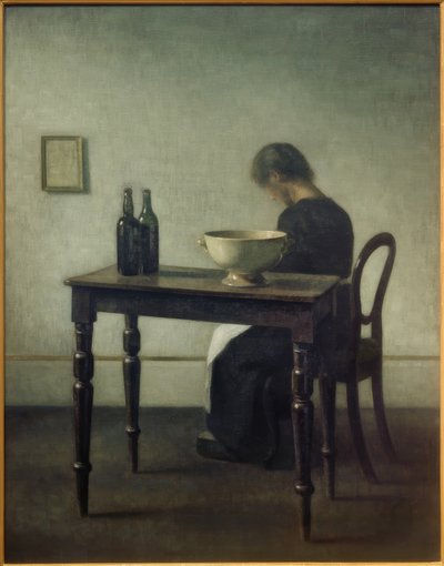 Kvinne sitter bak et bord av Vilhelm Hammershoi