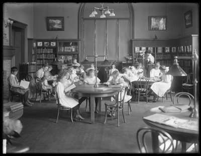 Barn som leser på lesesalen til en uidentifisert filial av Queens Borough Public Library, ca. 1910 av William Davis Hassler