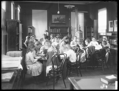 Barn som leser på lesesalen til en uidentifisert filial av Queens Borough Public Library, ca. 1910 av William Davis Hassler