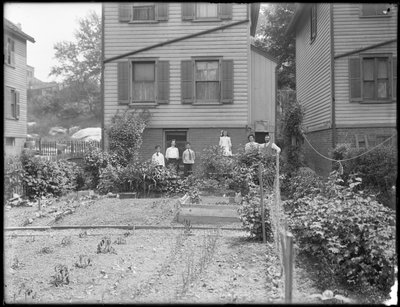 Familien poserer ved siden av grønnsakshagen i bakgården, Inwood, New York, ca. 1910 av William Davis Hassler