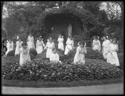 Avgangsklasse med jenter fra det romersk-katolske foreldreløse asylet i blomsterhagen, foran Jomfru Marias grotte, 1912 bw foto av William Davis Hassler