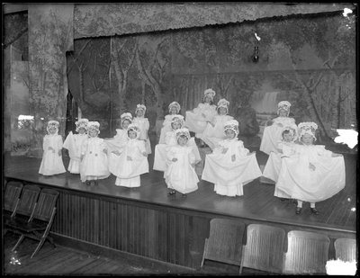 Barnehagebarn på scenen: veldig små jenter opptrer på en liten scene, sannsynligvis det romersk-katolske orphan asylum, Kingsbridge, Bronx, ca. 1911 av William Davis Hassler