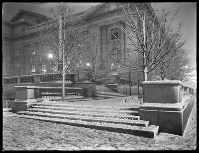 Nattutsikt over det nordøstlige hjørnet av trinnene utenfor hovedgrenen til New York Public Library i snøen, 42nd Street og Fifth Avenue, New York City, 6. mars 1915 av William Davis Hassler