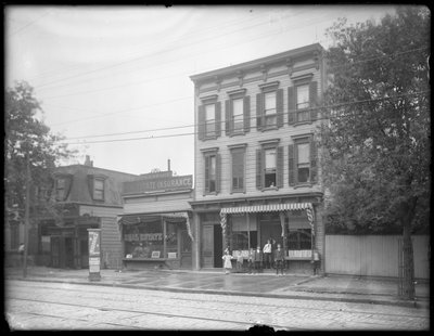 Syv barn poserer foran en uidentifisert gren av Queens Borough Public Library, New York, ca. 1910 av William Davis Hassler
