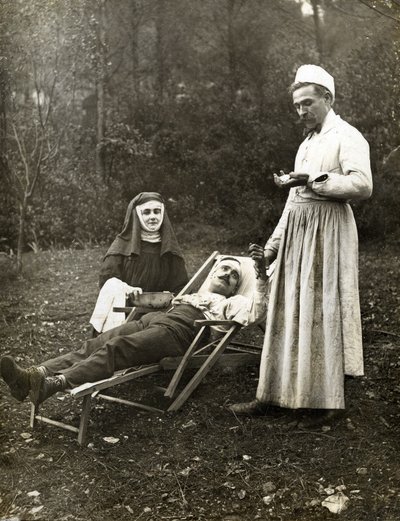 Lege tar pulsen til en skadet mann, assistert av en sykepleier nonne, ca. 1900 (s/hvitt-bilde) av . .
