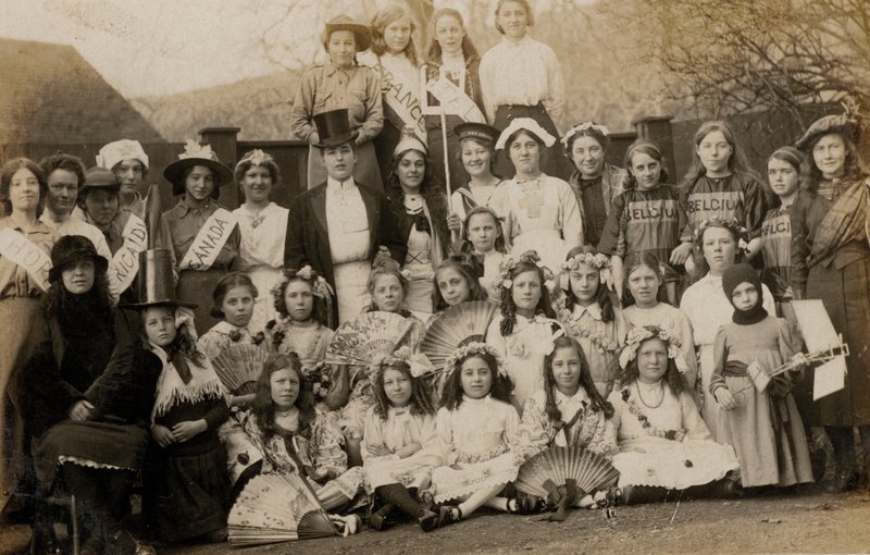 Portrett av en gruppe skolejenter med lærerne kledd i verdens kostymer (s/hv-bilde) av English Photographer