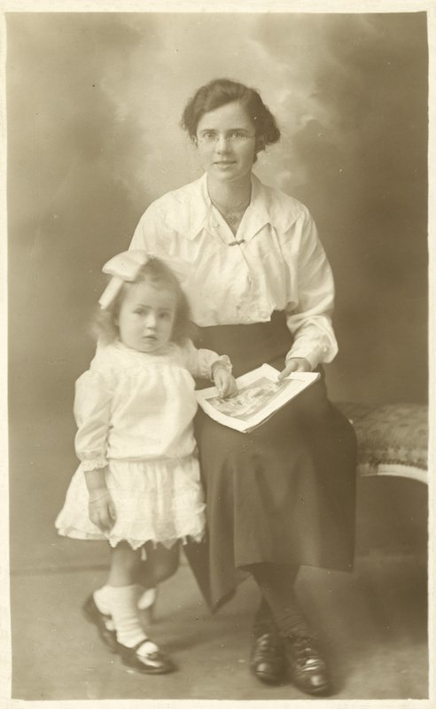 Pen jente, mor eller guvernante, viser bilder til små barn (s/hvitt-bilde) av English Photographer