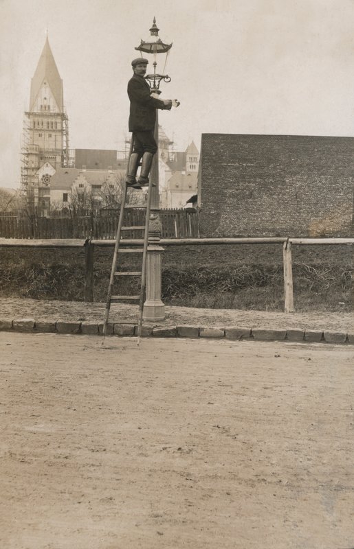 Mann opp en stige og fikser en gatelykt (s/hvitt-bilde) av European Photographer