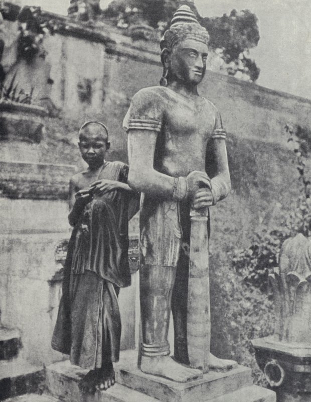 Ung buddhistisk nybegynnermunk ved siden av en statue av Buddha, Fransk Indokina (s/hvitt-bilde) av Ewing Galloway