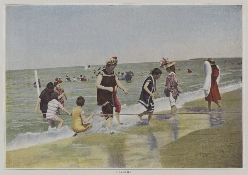 Barn som leker med et tau på stranden (fargebilde) av French Photographer