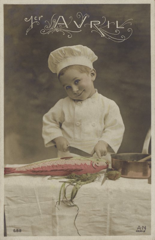Liten gutt koker en fisk (fargebilde) av French Photographer