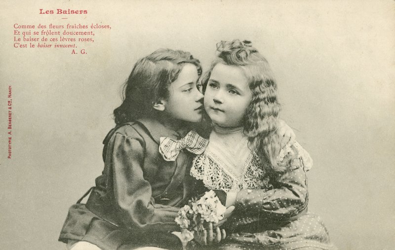 Liten gutt som kysser en liten jente (s/hvitt bilde) av French Photographer