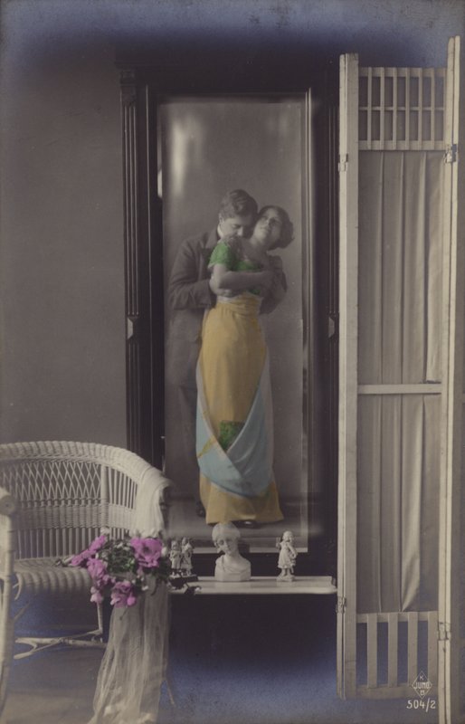 Refleksjonen i et speil av et ungt par som kysser (tonet bilde) av French Photographer