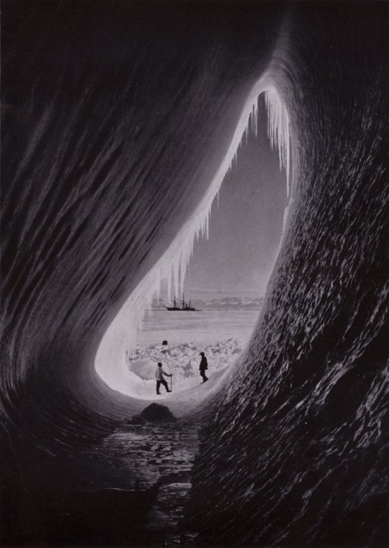 Grotte i et isfjell; Terra Nova i det fjerne (s/hvitt bilde) av Herbert Ponting