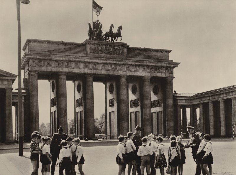 Unge pionerer kommer til Brandenburger Tor, Berlins landemerke, for å se vennene sine, grensevaktene (s/hv-bilde) av Photographer German