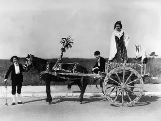 Villa Rosa Maltoni Mussolini: portrett av en gruppe ungdommer iført tradisjonelle sicilianske kostymer, poserer på en typisk vogn i regionen (s/hv-bilde)