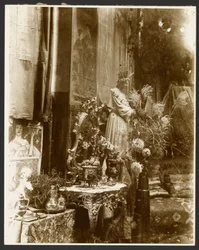 [Et hjørne av Muchas studio med statuer, trykk og blomster, Rue du Val-de-Grâce, Paris]