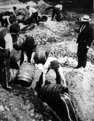 En amerikansk føderal agent fører tilsyn med ødeleggelsen av ølfat under den amerikanske forbudstiden (1920-33) (s/hvitt-bilde)