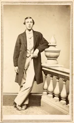 Uidentifisert mann i toppfrakk lent mot søyle, ca. 1860-75 (albumintrykk)