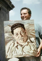 Den italienske maleren og forfatteren Carlo Levi (1902–1975) holder et av verkene sine, et portrett av fagforeningsmannen Giuseppe di Vittorio (foto)