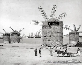 Vindmøller ved Middelhavet i Alexandria, Egypt. Foran poserer noen egyptere med en liten vogn.