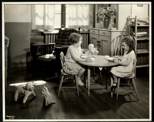 To blinde synshemmede jenter spiser ved et lite bord med dukke hos New York Association for the Blind, 111 East 59th Street, New York, 1933 (sølv gelatintrykk)