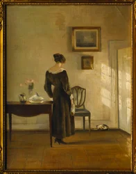Et interiør med en kvinne som mater en katt (olje på lerret)