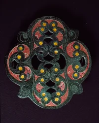 Keltisk kunst: gjennomboret bronseplate med emaljebelegg. 1. århundre e.Kr. Fra Paillard (Oise). Breteuil, arkeologisk museum