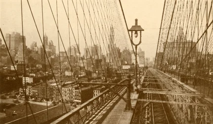 Nedre Manhattan sett gjennom nettverket av kabler på Brooklyn Suspension Bridge, c1930.