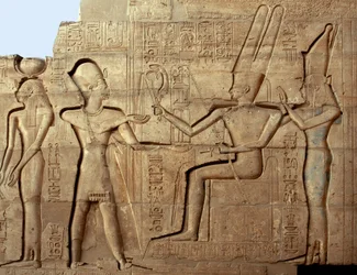 Egyptisk oldtid: relieff som avbilder farao Ramses II foran to av guddommene i den tebanske triaden, Amon og Mut; gravtempel viet til farao Ramses II (1279-1213 f.Kr.), Ramesseum-området i Luxor, Egypt.