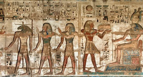 Egyptisk antikvitet: første domstol, detalj av malte relieffer som viser faraoen som bærer ofringer til gudene Horus og Khnoum. Begravelsestempelet til Ramses III (1187–1156 f.Kr.). Luxor, Medinet Habou, Egypt