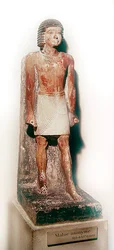 Statue av en stående mann med en hvit shenti (malt kalkstein)