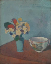 Vase med blomster og kopp